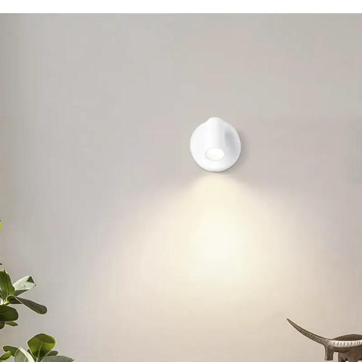 Applique murale LED sans fil Luminaire Essenza avec interrupteur, intensité variable et base magnétique sur un mur blanc.