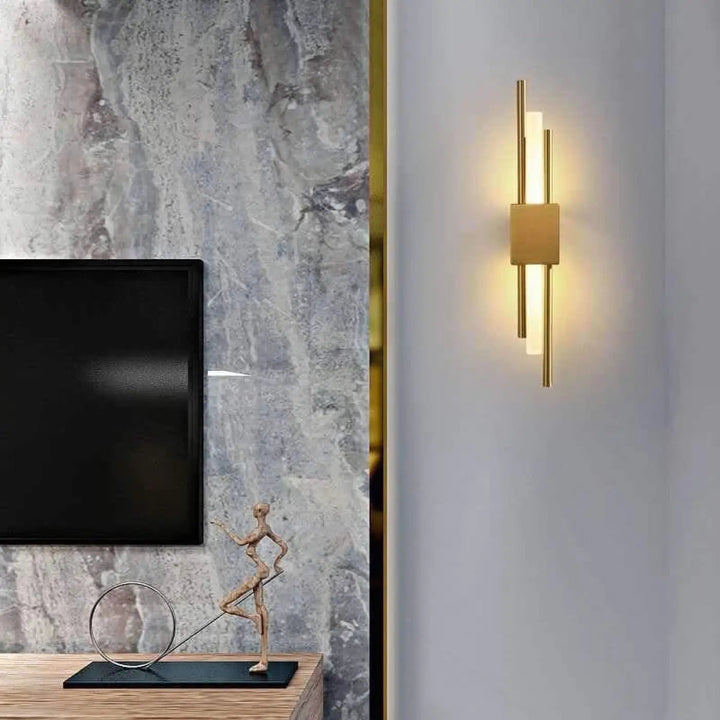 Applique murale design LED en laiton pour salon, style moderne et élégant, installation verticale.