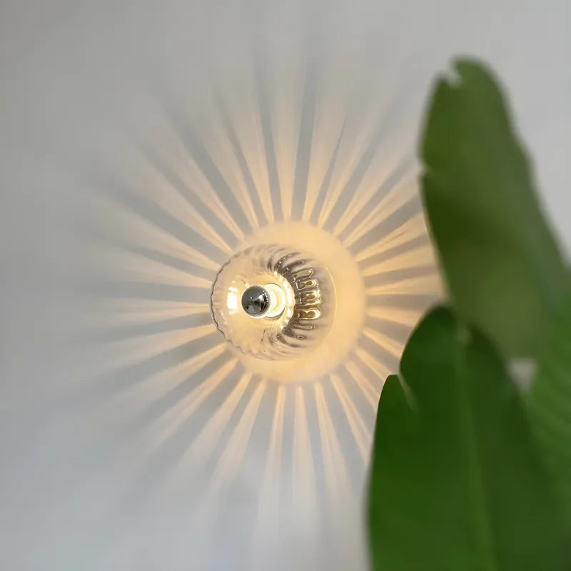 Applique murale en verre avec effet soleil, design élégant et moderne, par Luminaire Essenza, pour décoration intérieure.