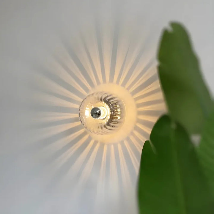 Applique murale en verre avec effet soleil, design élégant et moderne, par Luminaire Essenza, pour décoration intérieure.