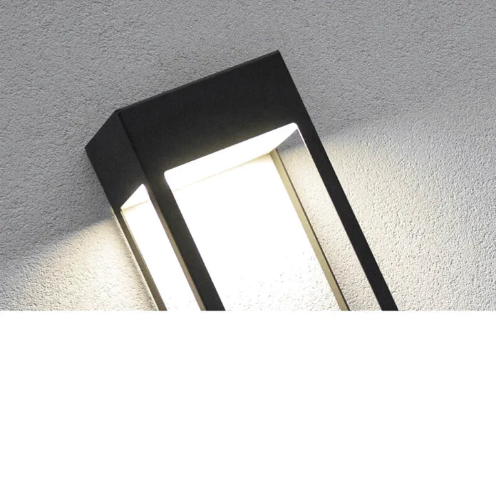 Applique murale extérieure étanche noire de design moderne de la marque Luminaire Essenza, fixée sur un mur extérieur.
