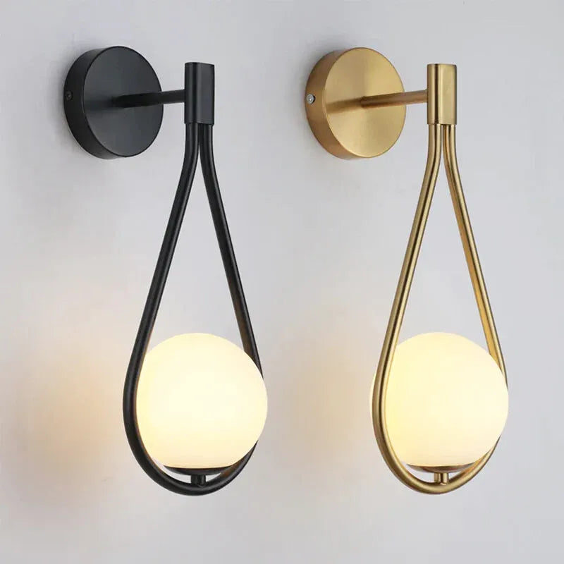 Applique murale LED en verre avec sphère suspendue, finition or blanc chaud, éclairage moderne pour intérieur.