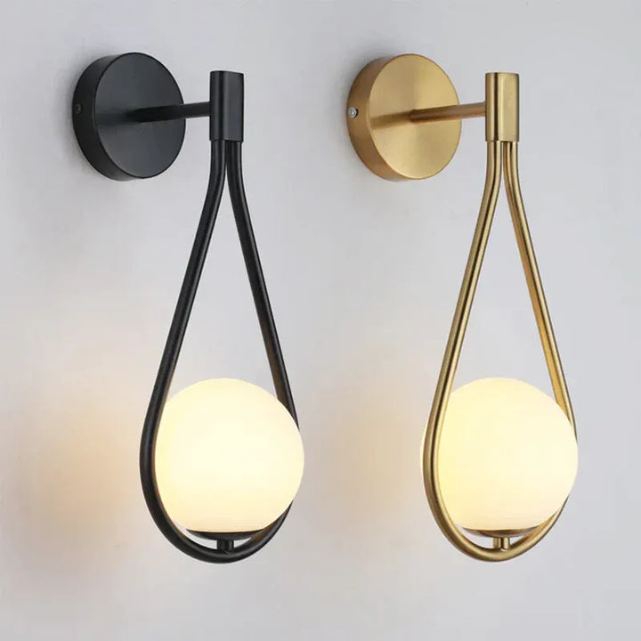 Applique murale LED en verre avec sphère suspendue, finition or blanc chaud, éclairage moderne pour intérieur.