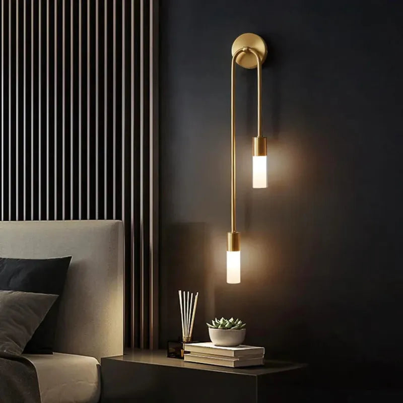 Applique murale LED minimaliste au design nordique décoratif avec finition or, fixée sur un mur blanc, style moderne et élégant.