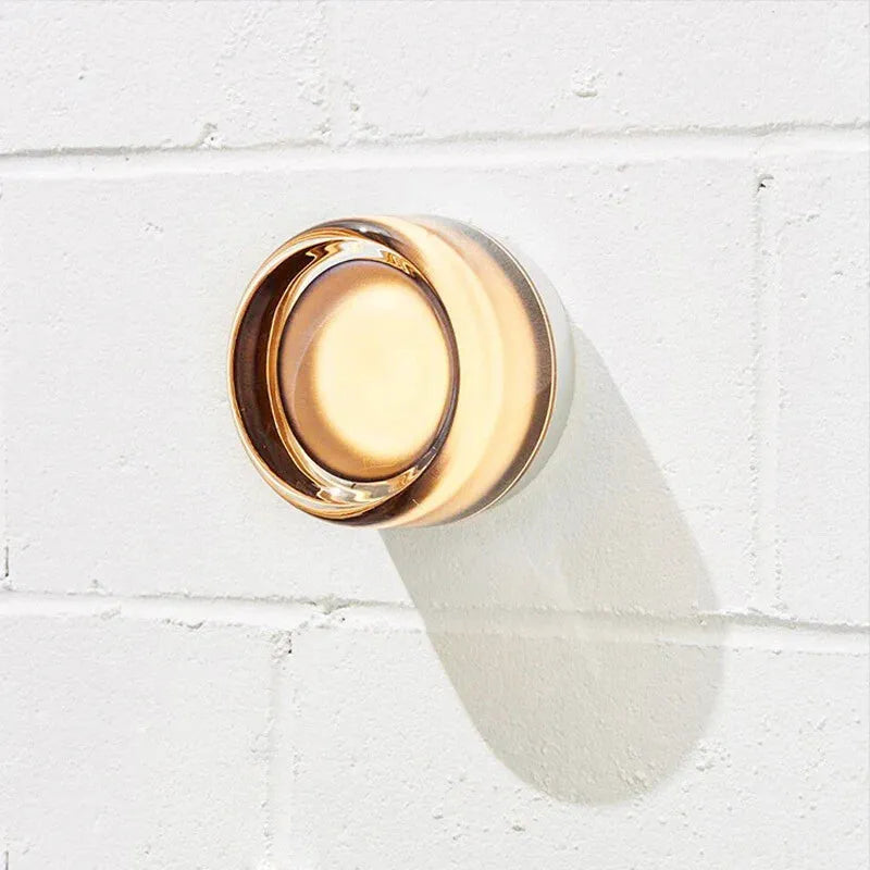 Applique murale LED moderne et décorative en cylindre, de la marque Luminaire Essenza, illuminant un mur intérieur.