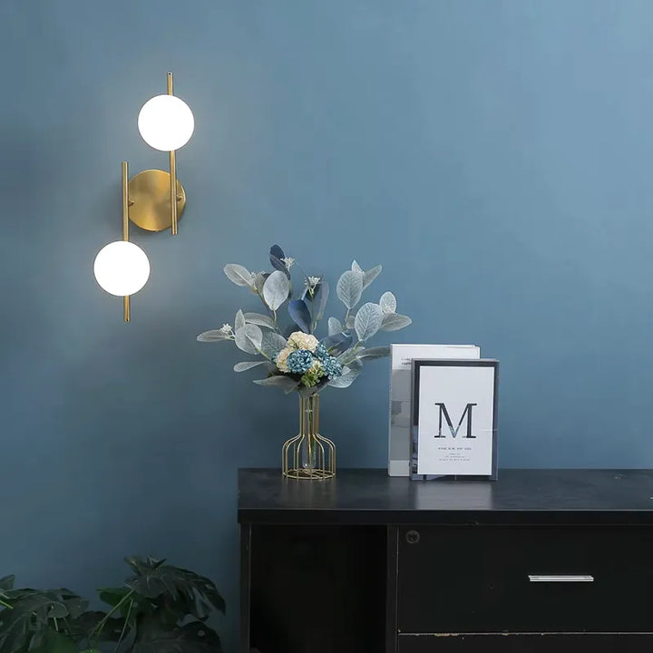 Applique murale LED moderne Luminaire Essenza en verre et métal, double sphère or, éclairage décoratif pour mur intérieur.