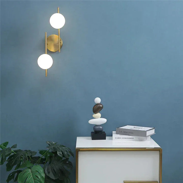Applique murale LED moderne en verre et métal, double sphère, finition or, éclairage élégant pour intérieur contemporain.
