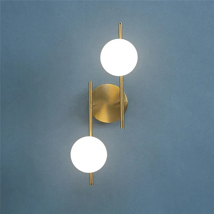 Applique murale LED moderne en verre et métal avec double sphère, design épuré, finition or, éclairage élégant pour intérieur.