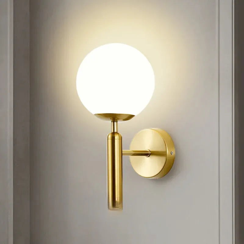 Applique murale moderne sphérique en or de la marque Luminaire Essenza, éclairage élégant pour intérieur.