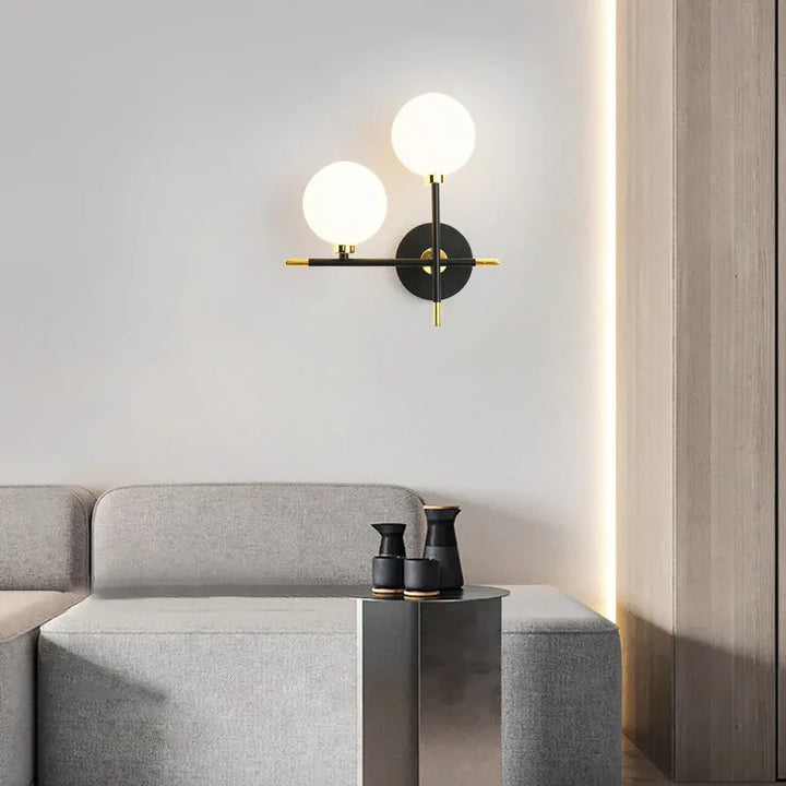 Applique murale nordique Luminaire Essenza avec double globe en verre blanc, design moderne et élégant pour intérieur.