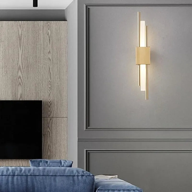 Applique murale design LED en laiton pour salon, style moderne et élégant, avec lumière douce et finition raffinée.
